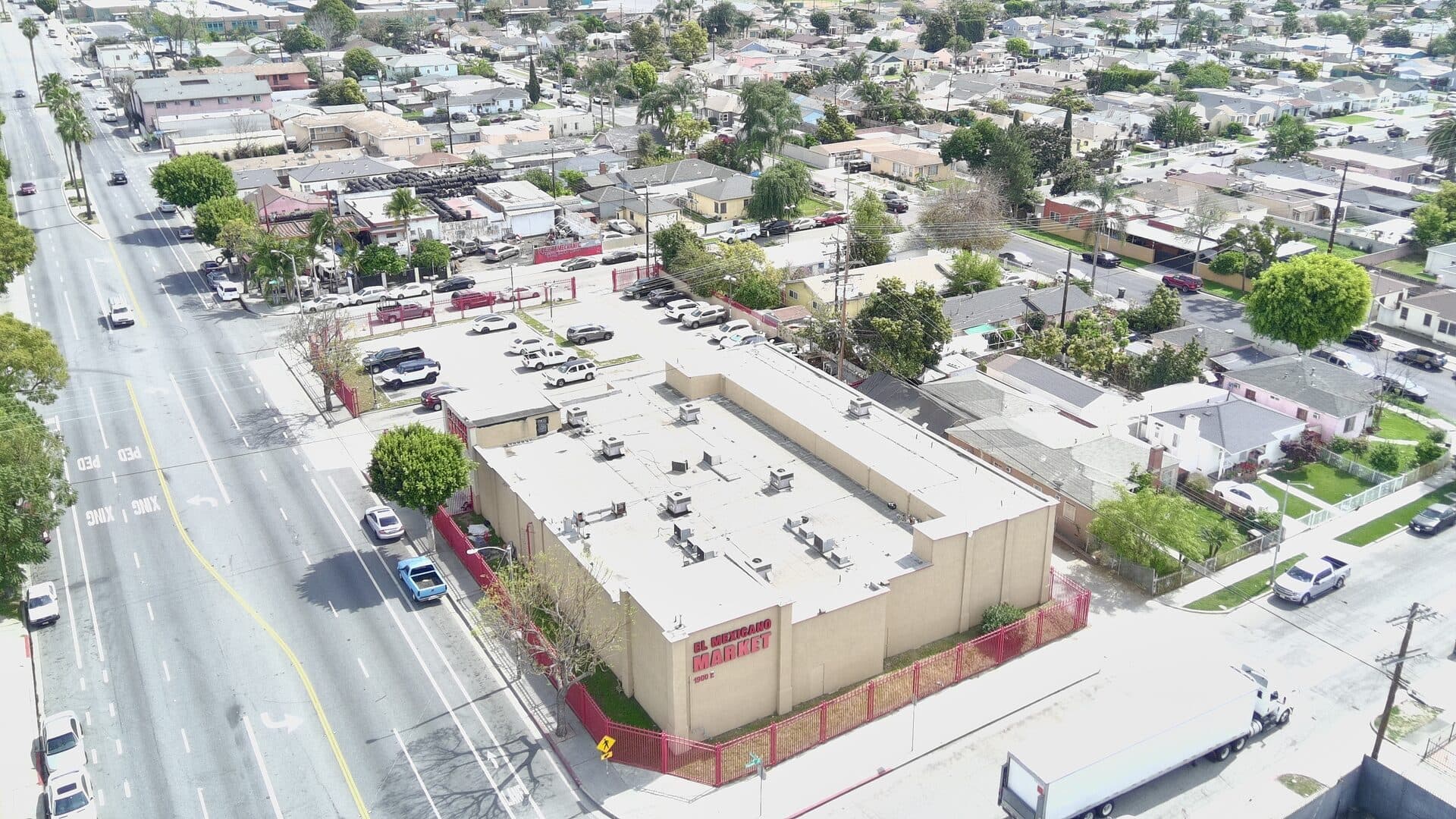 Drone view — building corner positioning, parking, and surrounding businesses