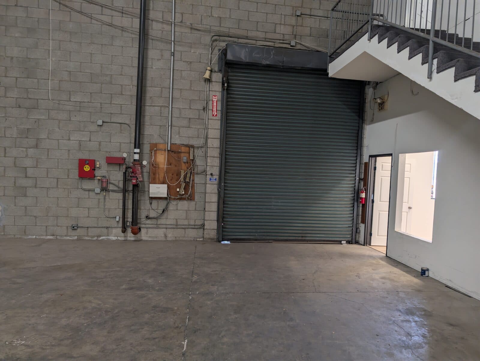 Interior ground-level roll-up door and fire-sprinkler riser at 2120 S Main St