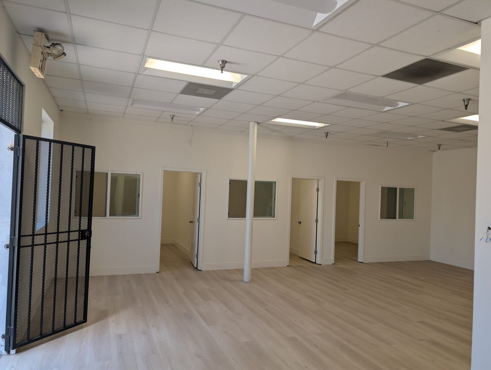 Renovated office buildout at 2120 S Main St with private offices and security cage door