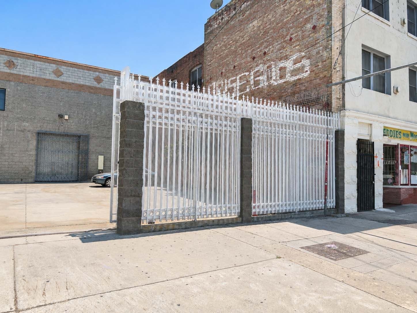 Steel perimeter security fencing along the Main Street frontage at 2120 S Main St