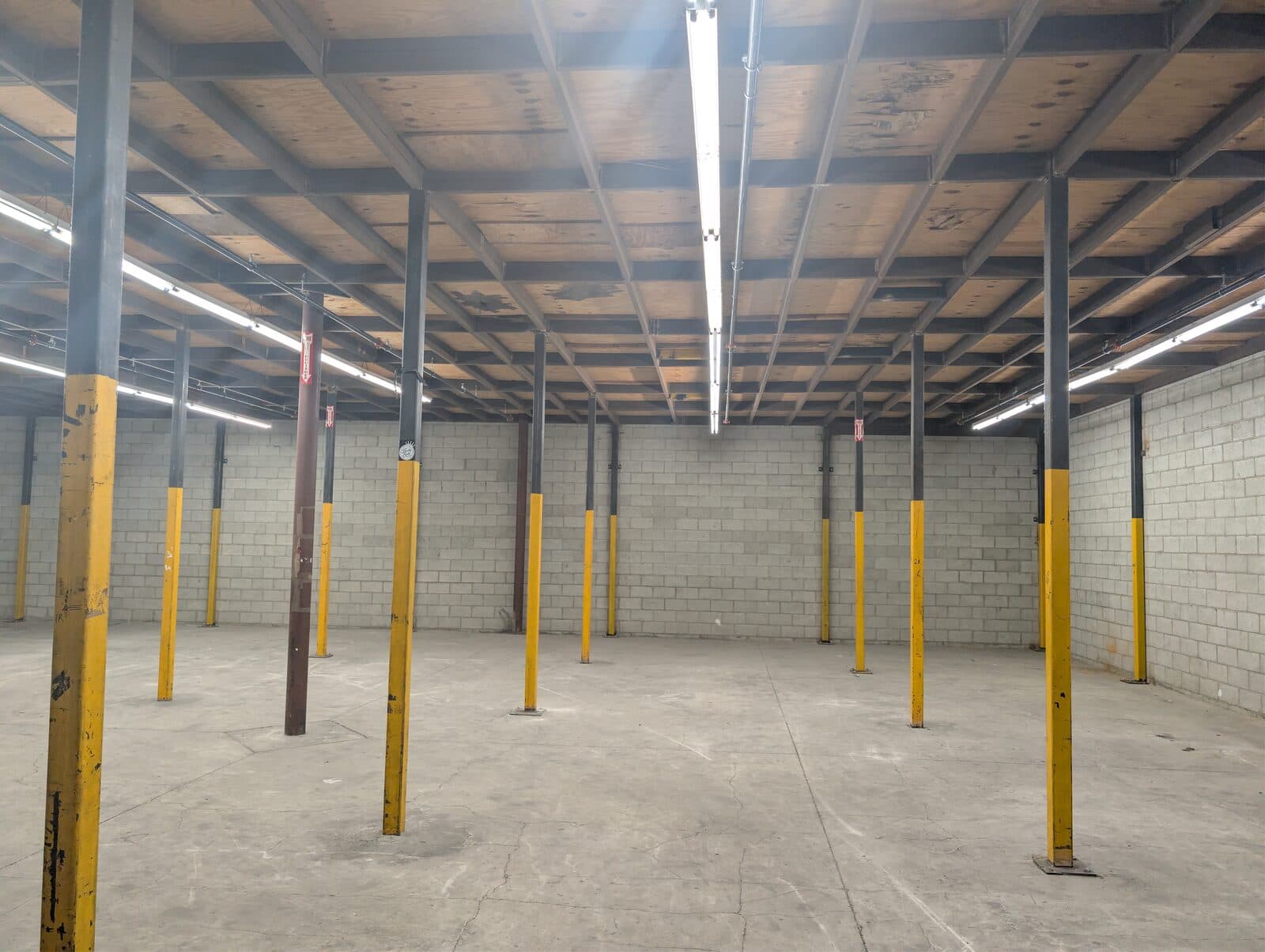 Ground-floor warehouse at 2120 S Main St — open floor plate with protected steel columns