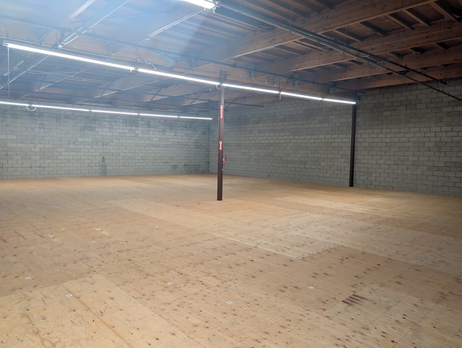Second-floor warehouse level at 2120 S Main St — open wood deck under the bow-truss roof