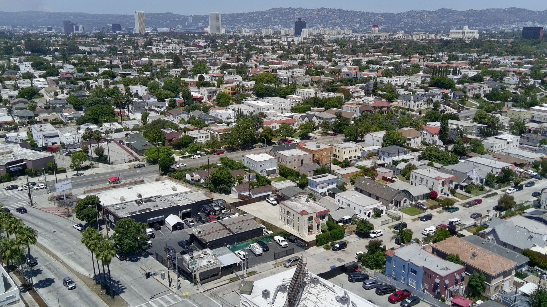 Wide aerial — Mid-City / Pico corridor with the Los Angeles skyline beyond