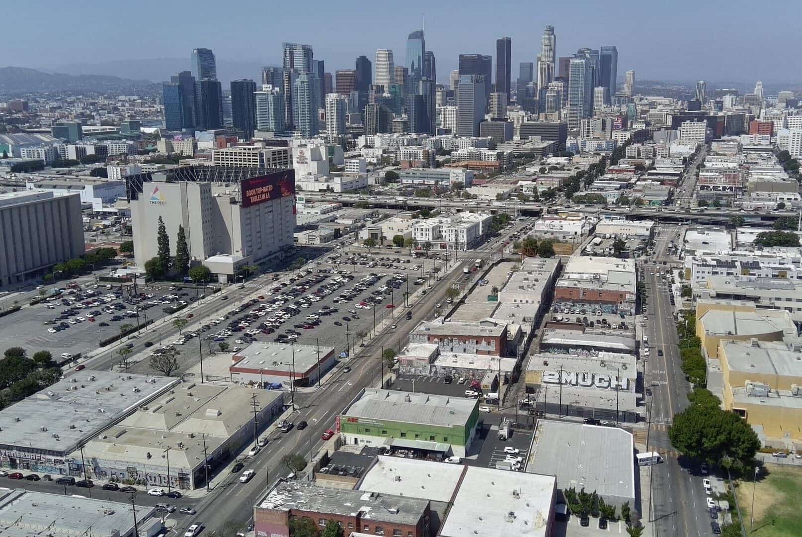 Drone aerial above 2120 S Main St looking up the South Main corridor to the Downtown Los Angeles skyline