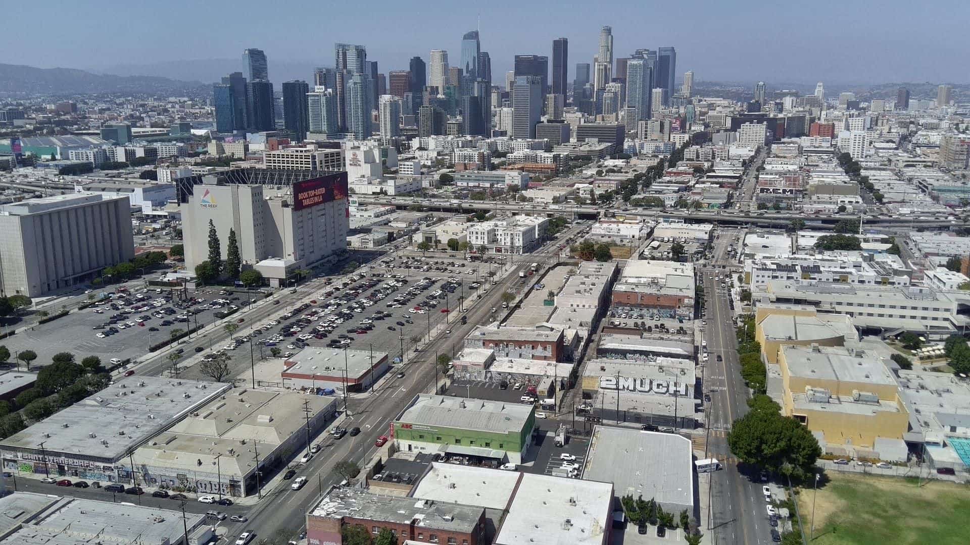Drone aerial above 2120 S Main St looking up the South Main corridor to the Downtown Los Angeles skyline